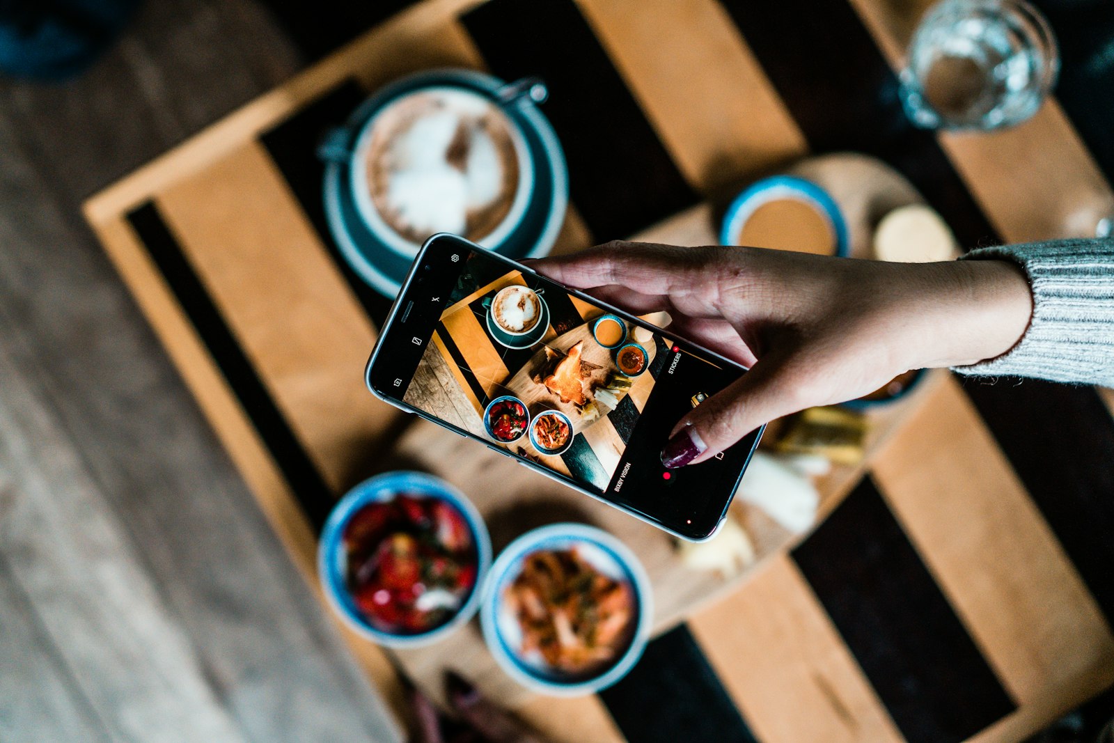 Persona fotografiando un platillo con su teléfono para redes sociales